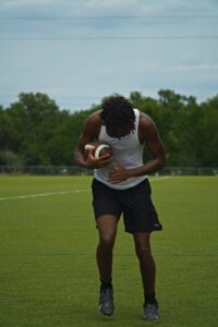 a man holding a ball on a field