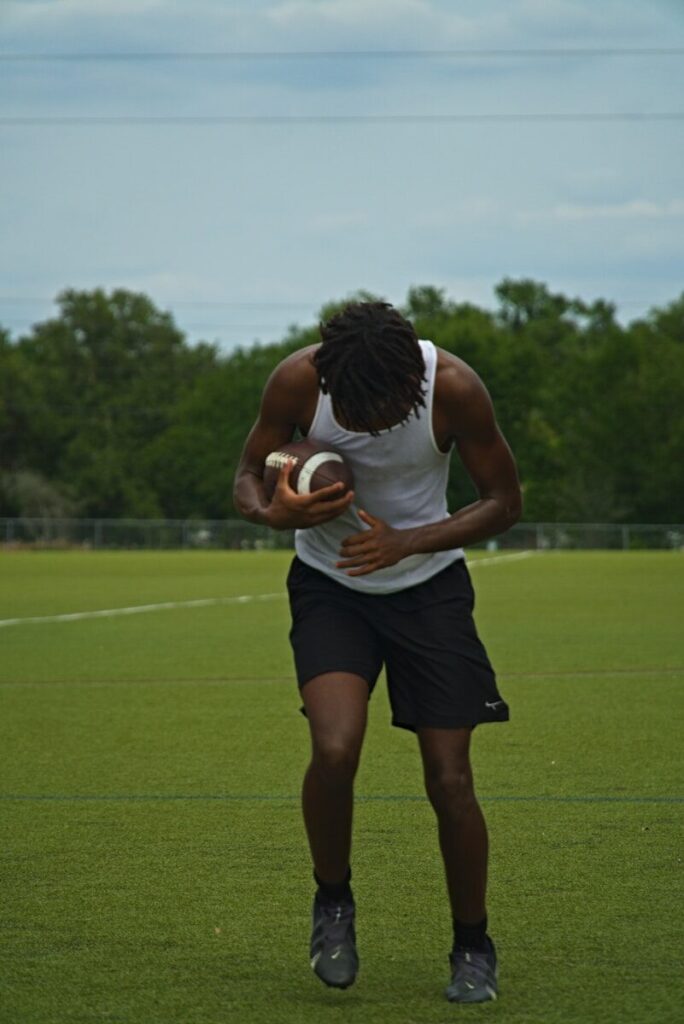 a man holding a ball on a field